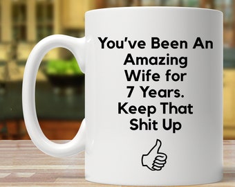 May include: White ceramic coffee mug with black text that reads "You've Been An Amazing Wife for 7 Years. Keep That Shit Up" with a thumbs up icon.