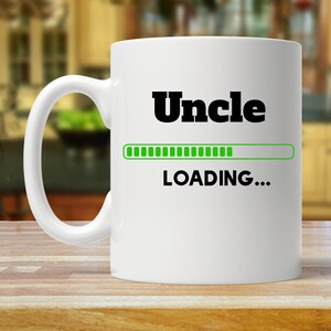 May include: White ceramic mug with a black graphic that says "Uncle" and a green progress bar that says "LOADING..."