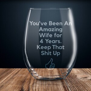May include: A clear glass wine glass with the text "You've Been An Amazing Wife for 4 Years. Keep That Shit Up" etched on the side. A thumbs up icon is also etched on the glass.
