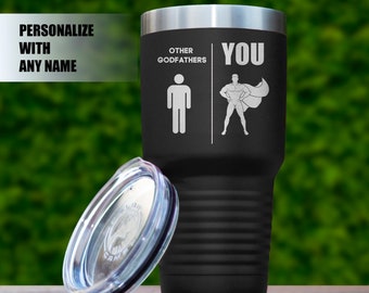 May include: Black stainless steel tumbler with a lid. The tumbler has a white design that says "Other Godfathers" with a stick figure and "You" with a stick figure wearing a cape.