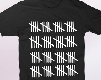 以下が含まれることがあります： 白いカウントマークのパターンが施された黒いTシャツ。カウントマークはグリッドパターンに配置されています