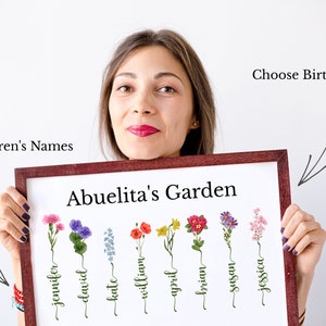 May include: A framed print with the title "Abuelita's Garden" featuring a watercolor illustration of eight different flowers with names written underneath each flower. The names are Jennifer, David, Kate, William, April, Brian, Susan, and Jessica. The text "Grandchildren's Names" is written above the flowers and "Choose Birth Flowers" is written above the frame.