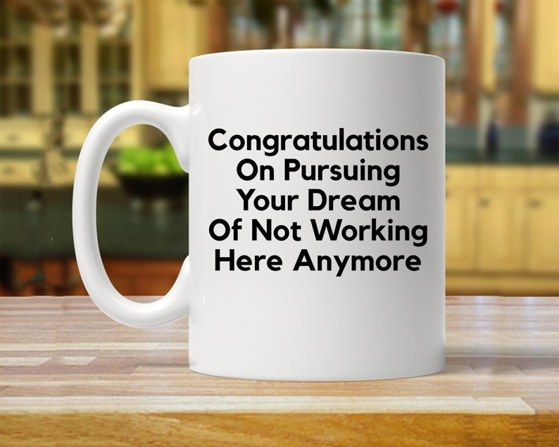 Puede incluir: Taza de caf&eacute; de cer&aacute;mica blanca con texto negro que dice "Felicidades por perseguir tu sue&ntilde;o de no trabajar aqu&iacute; m&aacute;s".