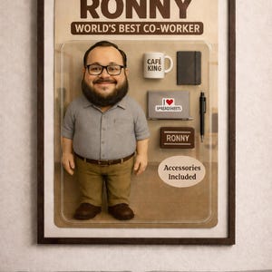 Pu&ograve; includere: Un oggetto di novit&agrave; incorniciato con una statuina di un uomo con occhiali e barba, etichettato "RONNY, WORLD'S BEST CO-WORKER". Gli accessori includono una tazza, un taccuino, un laptop, una penna e una targhetta. La confezione recita "Accessori inclusi".