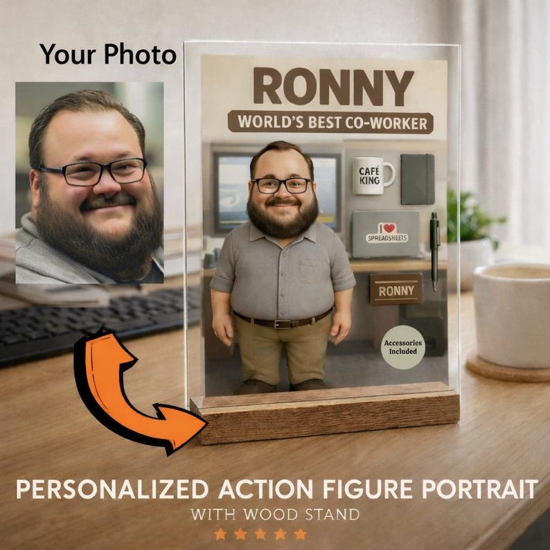 Pu&ograve; includere: Ritratto personalizzato di una action figure con base in legno. La figura &egrave; di un uomo con occhiali e barba, con la scritta "RONNY, WORLD'S BEST CO-WORKER". Gli accessori includono una tazza, un taccuino e una penna. La base ha il testo "PERSONALIZED ACTION FIGURE PORTRAIT WITH WOOD STAND."
