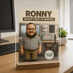 Pu&ograve; includere: Un espositore da scrivania con una figura a cartone animato di un uomo con occhiali e barba, etichettato "Ronny, World's Best Co-Worker". Gli accessori includono una tazza da caff&egrave;, un taccuino e un cartello con scritto "I ❤️ Spreadsheets".