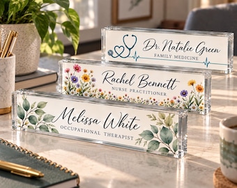 Puede incluir: Tres placas de escritorio rectangulares de acrílico transparente. La placa superior presenta un estetoscopio azul y el texto Dr. Natalie Green FAMILY MEDICINE. La placa central muestra flores silvestres coloridas y el texto Rachel Bennett NURSE PRACTITIONER. La placa inferior muestra hojas verdes y el texto Melissa White OCCUPATIONAL THERAPIST.