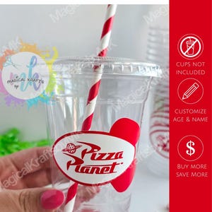 May include: A clear plastic cup featuring a white oval sticker with the red Pizza Planet logo and a red planet graphic. The cup includes a red and white striped straw. Text on the side indicates stickers only, cups not included, and customization.