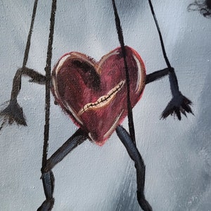Pu&ograve; includere: Un burattino a forma di cuore rosso con labbra cucite e arti neri &egrave; sospeso da delle corde su uno sfondo blu chiaro.