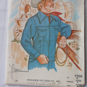 Könnte beinhalten: Vintage Schnittmuster mit einer Cowboy-Illustration in blauer Jeanskleidung, einem roten Halstuch und einem Cowboyhut. Der Hintergrund zeigt einen Planwagen und einen Zaun. Entworfen von Kerstin Martensson.