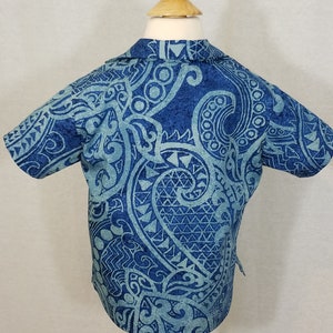 Puede incluir: Una camisa de manga corta azul y azul claro con estampado y cuello.