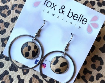 Dangle earrings featuring a 3cm hoop and 14mm leopard leather bezel. Surgical stainless steel. All hypoallergenic.
