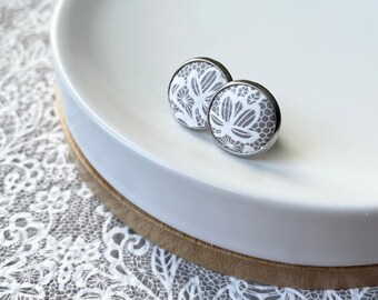 Leather studs in white and beige lace print. Hypoallergenic surgical stainless steel bezel. Lace studs. White earrings.