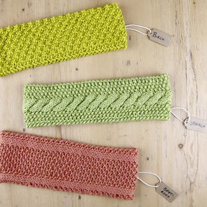 Może przedstawiać: Trzy dzianinowe opaski na głowę w różnych kolorach i wzorach. Opaski są oznaczone jako "Birch", "Spinach" i "Beet Root".