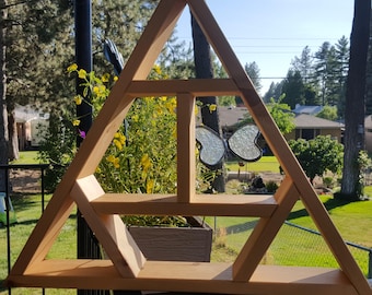 May include: A triangular wooden shelf with three shelves. The shelf is made of natural wood and has a rustic look. The shelf is decorated with two glass butterflies.