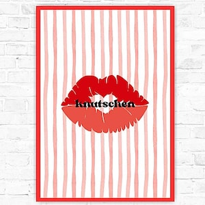 May include: A framed print with a red lip design and the German word "knutschen" in black. The background has vertical red and white stripes, and the frame is red. The artwork is displayed against a white brick wall.