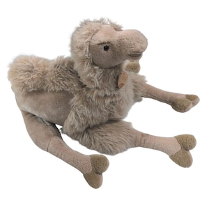 May include: A plush camel toy with soft, light brown fur, a textured hump, and dark brown hooves. The stuffed animal features a small, light brown tag attached to its neck and has a realistic facial expression with dark, round eyes.