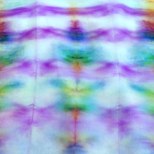 Könnte beinhalten: Abstrakte Textilkunst mit einem lebendigen Batik-Effekt. Das Design zeigt eine Mischung aus Farben, darunter Lila, Blau, Grün, Gelb, Orange und Braun. Das Muster ist eine Mischung aus horizontalen und vertikalen Linien und erzeugt eine einzigartige visuelle Textur.