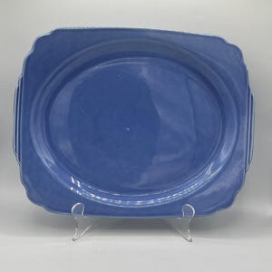 May include: A light blue oval serving platter with a slightly raised rim and a smooth, glossy finish.