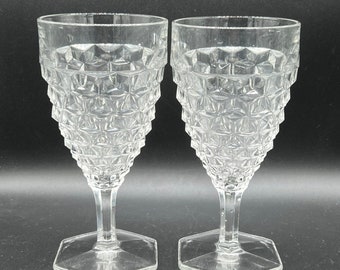 May include: Two clear glass goblets with a diamond pattern. The goblets have a hexagonal base.