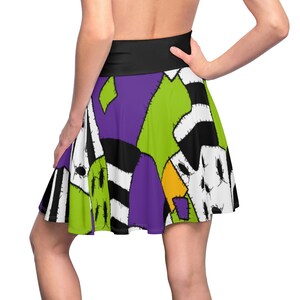 May include: A black, green, purple, and white skater skirt with a patchwork design. The skirt has a black waistband and is made of a soft, comfortable fabric.
