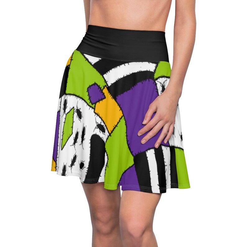 May include: A green, purple, yellow, and black skater skirt with a patchwork design. The skirt has a black waistband and is made of a stretchy fabric.