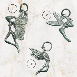 May include: Three silver fairy charms with key rings. One charm features a fairy with butterfly wings, another a fairy with outstretched wings, and the third a fairy in a flying pose. These charms are suitable for jewellery making or as decorative accents.