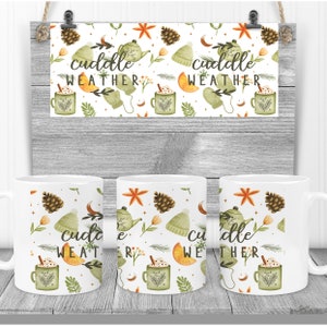 May include: Three white mugs with a wintery design featuring a teapot, pine cones, mittens, and the text "cuddle weather".