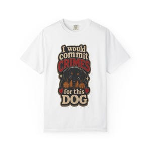 May include: A white short-sleeved t-shirt featuring a graphic print of a Rottweiler puppy. The text reads I would commit CRIMES for this DOG in black and red lettering, accented with two small red hearts on either side of the puppy illustration.