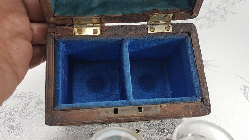May include: A wooden box with a hinged lid, lined with blue velvet. The box has two compartments inside.