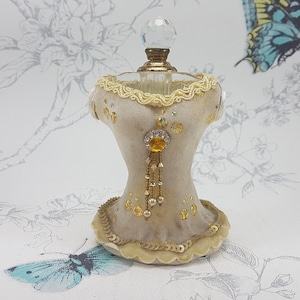 Porta perfumes vintage con corsé: decoración de tocador con joyas