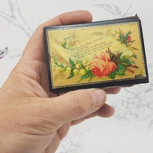May include: A small, black, rectangular box with a gold floral design and a scroll with the text "Think, dear friend, when thou art wandering, as I am, and to thee, in this path, so red to thine, With the same hopes and changes, Think of me as I think of thee."