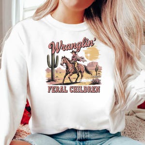 Wranglin’ Feral Children PNG | Funny Western Mom on Horse Clipart | Cowgirl Chaos Sublimation Design | Digital Download for Shirts