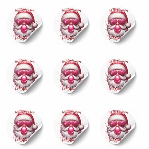 May include: Nine white stickers featuring a Santa Claus design. Santa wears a red hat and heart-shaped sunglasses. The text "Tis the Season" and "To Spa" are printed on each sticker. The Santa's beard is white and he has a pink bubble.