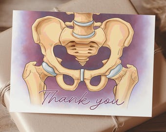 May include: A greeting card featuring an illustration of a human pelvis in shades of beige and blue, with the words "Thank you" in cursive. The card rests on a wrapped gift box with twine, set against a wooden surface.