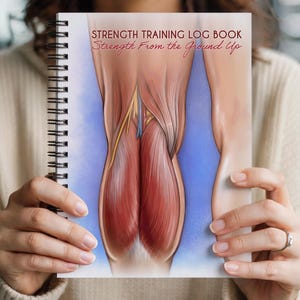 May include: A spiral-bound notebook titled "Strength Training Log Book" with the text "Strength From the Ground Up." The cover features a detailed anatomical illustration of leg muscles against a blue backdrop. The notebook is held open.