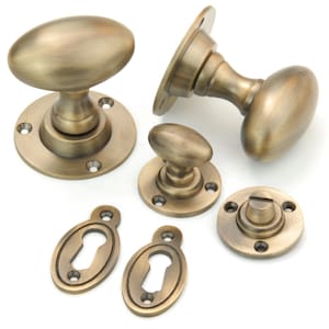 May include: Antique brass oval door knobs and escutcheons with keyhole covers.