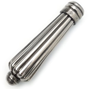 May include: A silver bottle stopper with a ribbed, cylindrical body and rounded ends. The stopper has a decorative design and is likely made of metal. The design is symmetrical and is set against a white background.