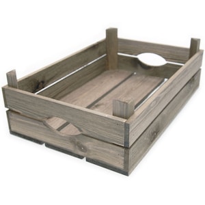 May include: A grey-washed wooden crate. It features a slatted base and sides, with hand-hold cutouts on the short ends. The corners are reinforced with vertical supports. This crate is suitable for storage or display, and measures approximately 40cm in length.