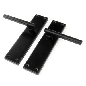 May include: Two black door handles with square backplates and a rectangular lever.