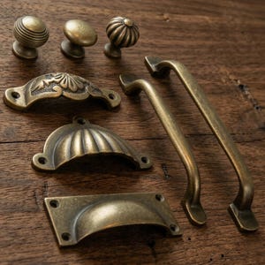 May include: A white ceramic mug with a black handle and the text "But First, Coffee" in a black, bold font. The mug is on a wooden surface. The mug is approximately 10 cm tall.