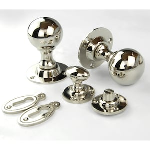 May include: A set of polished nickel door knobs with a round design. The set includes two door knobs, two keyhole escutcheons, a round knob, and a round latch.