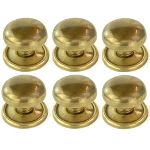 May include: Six antique brass door knobs. Each knob features a rounded top and a circular base. The knobs are arranged in two rows of three, highlighting their classic design and warm, metallic finish. Perfect for vintage home decor.