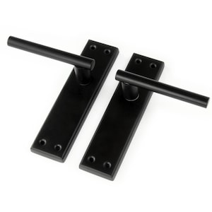 May include: Two black door handles with square backplates and a long, straight lever.