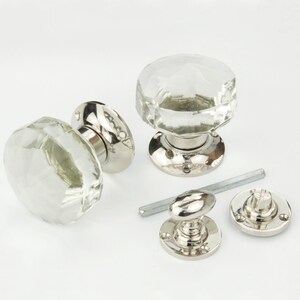 May include: Clear faceted crystal door knobs with polished chrome bases and hardware. The knobs have a classic, elegant design. Includes a set of two knobs, a spindle, and mounting hardware.