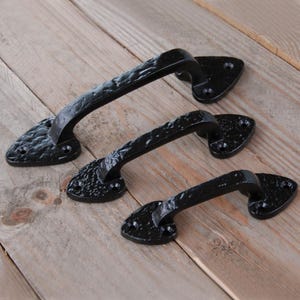 May include: A trio of cream-glazed ceramic mugs, each adorned with a hand-painted floral pattern in pinks, blues, and greens. The mugs have a speckled finish and a classic, rounded design with a handle. Ideal for tea or coffee.