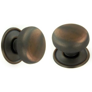 May include: Two antique-style cabinet knobs with a dark bronze finish. Each knob has a rounded, oval shape with a matching backplate. The knobs are made of metal and are designed for furniture or cabinet doors.