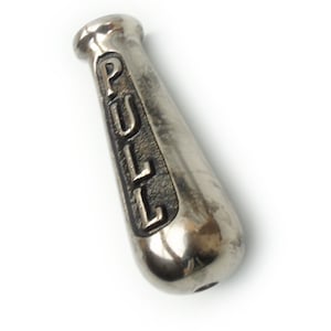 May include: A silver-coloured metal pull handle with the word "PULL" embossed vertically. The handle has a rounded, ergonomic shape, and a small hole at the base. The metal has a slightly aged appearance.