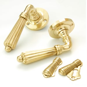 May include: A set of polished brass door handles with a fluted design. The handles are shown with the backplates and escutcheons.