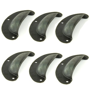 May include: Six antique-style drawer pulls with a dark, weathered finish. Each pull is a curved, cup-shaped design with two screw holes for mounting. The pulls are made of metal and have a vintage aesthetic.